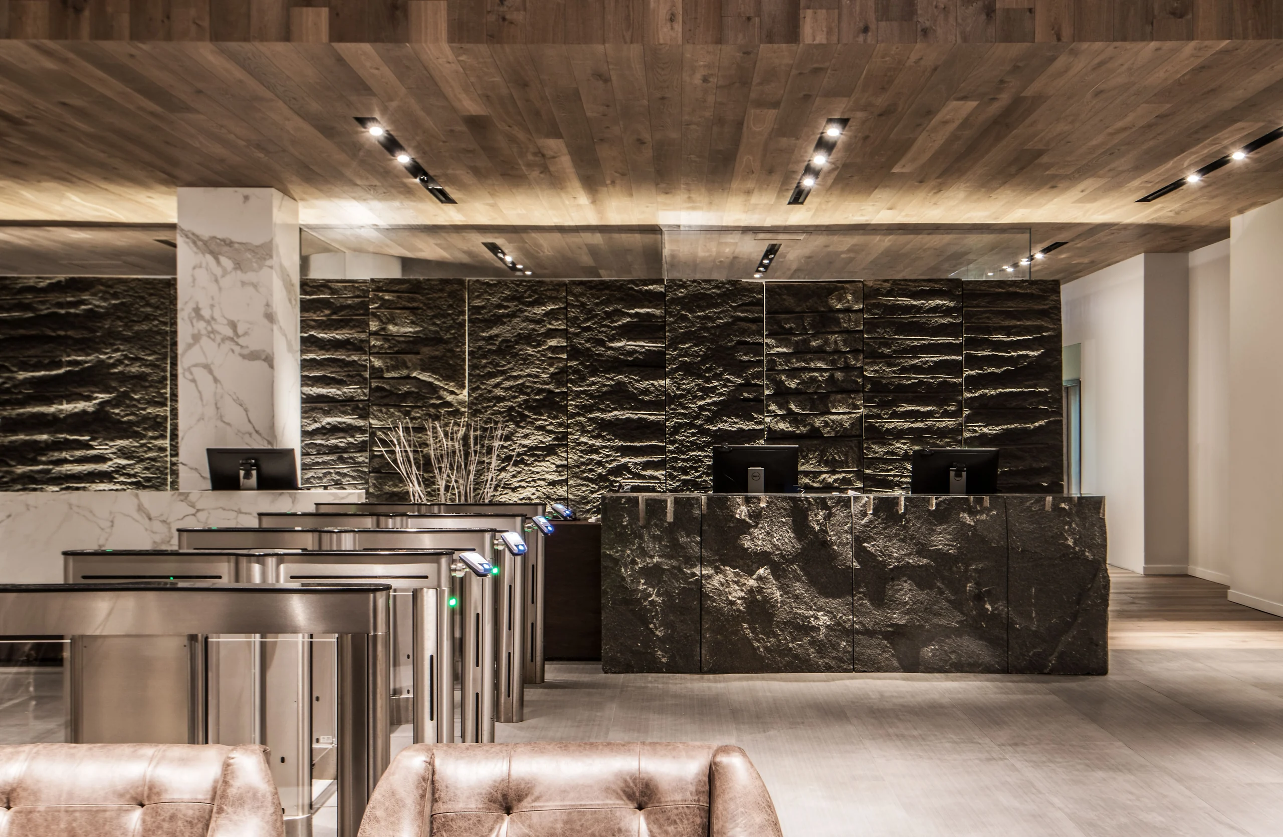 Commercial reception with a dark veined feature wall and pale counter