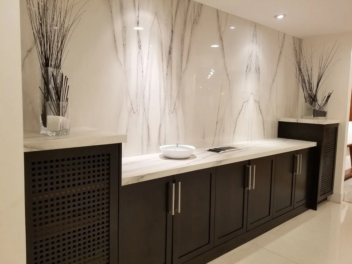 Full-height veined backsplash above dark kitchen cabinetry