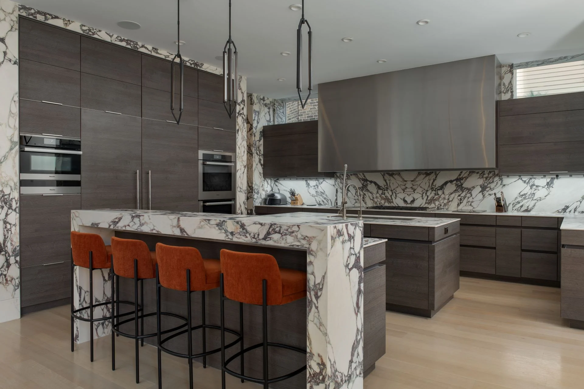 Veined porcelain kitchen island with dark cabinetry